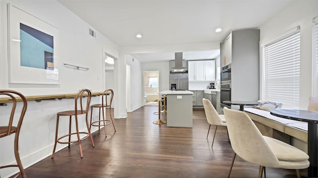 dining room featuring a healthy amount of sunlight and dark hardwood / wood-style floors