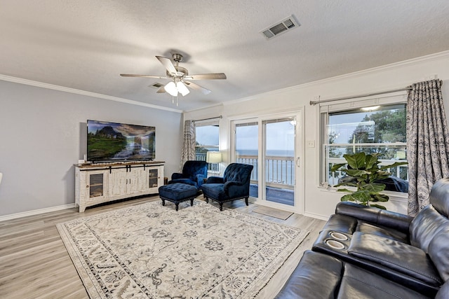 living room with ceiling fan, a textured ceiling, light hardwood / wood-style flooring, and crown molding