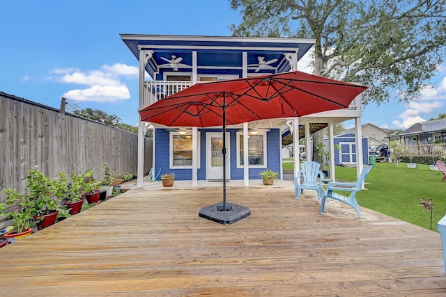 deck with a storage shed and a lawn