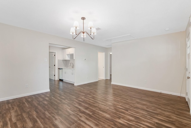 unfurnished living room with sink, dark hardwood / wood-style floors, and a notable chandelier