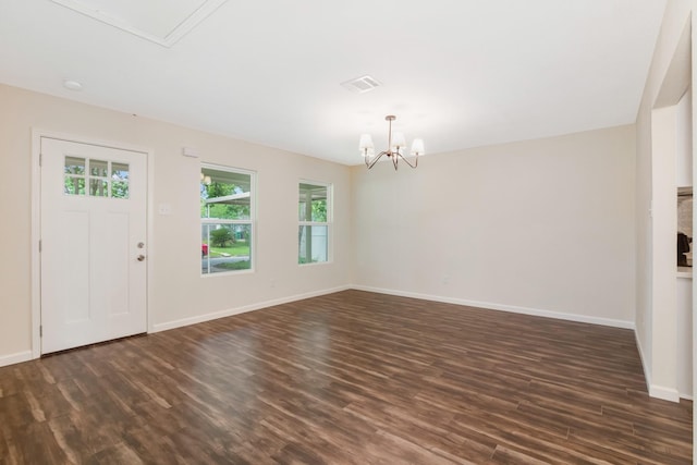 foyer with dark hardwood / wood-style flooring and a chandelier