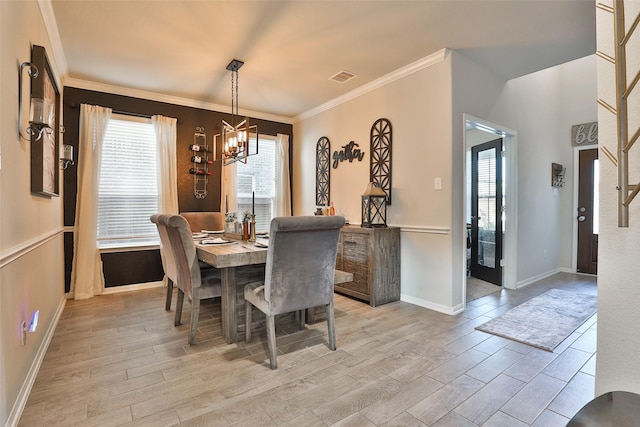 dining space with plenty of natural light, crown molding, and an inviting chandelier