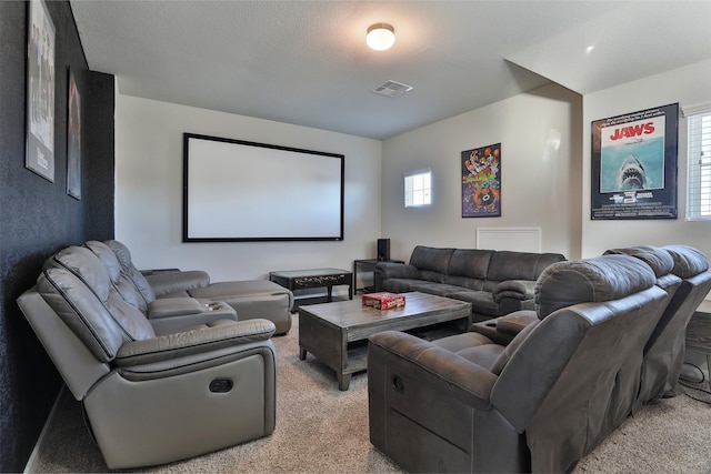 home theater featuring plenty of natural light, light colored carpet, and a textured ceiling