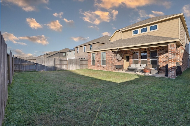 back of house with an outdoor living space, a lawn, and a patio