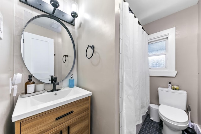 bathroom with toilet, vanity, and tile patterned floors