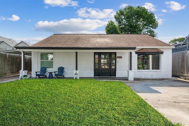 rear view of house with covered porch and a yard