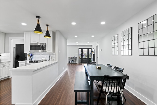 kitchen featuring decorative backsplash, white cabinets, appliances with stainless steel finishes, and kitchen peninsula