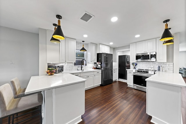 kitchen featuring stainless steel appliances, white cabinets, kitchen peninsula, and hanging light fixtures