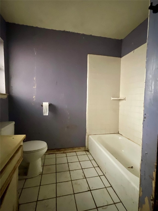 bathroom with toilet, vanity, tile patterned flooring, and a washtub