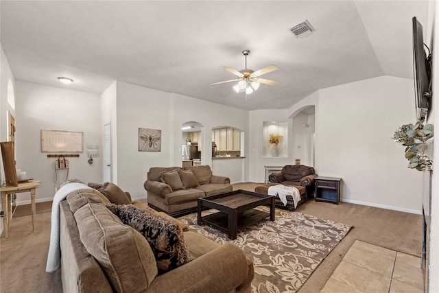 living room featuring ceiling fan, light carpet, and vaulted ceiling