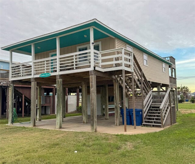 rear view of property with a patio area, a wooden deck, and a lawn