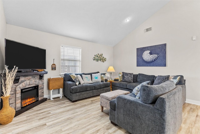 living area with a fireplace, light wood finished floors, visible vents, high vaulted ceiling, and baseboards