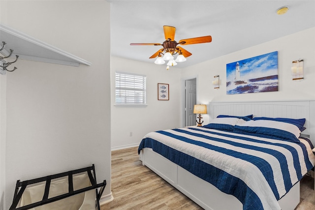 bedroom with ceiling fan, baseboards, and wood finished floors