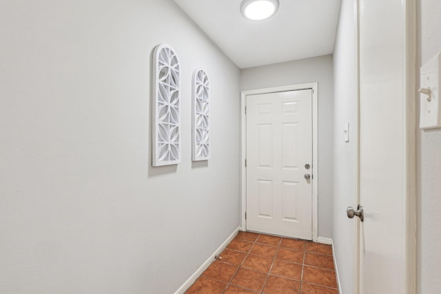 doorway with dark tile patterned floors