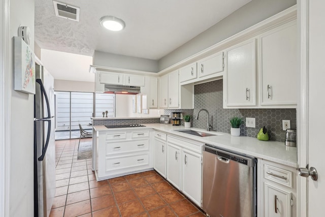 kitchen with backsplash, kitchen peninsula, sink, appliances with stainless steel finishes, and white cabinets