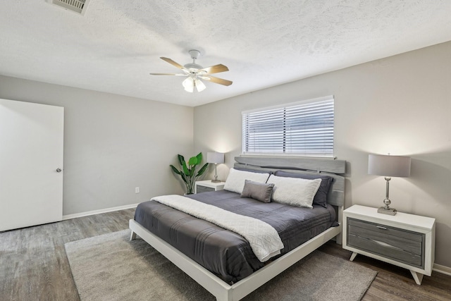 bedroom with ceiling fan, a textured ceiling, and hardwood / wood-style flooring