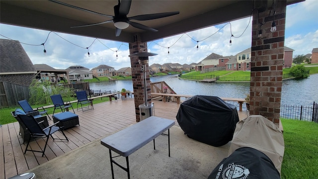 exterior space featuring ceiling fan, a deck with water view, and grilling area