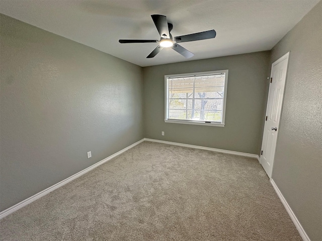 carpeted spare room with ceiling fan