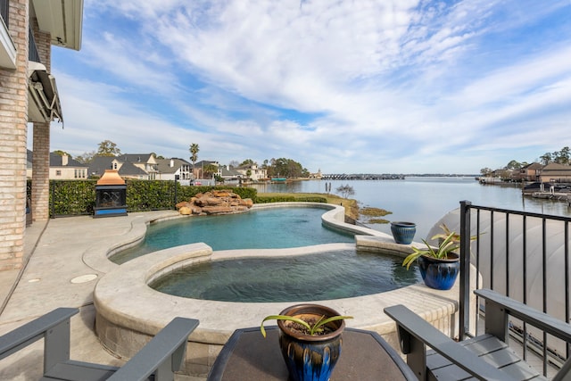 view of swimming pool with an in ground hot tub and a water view