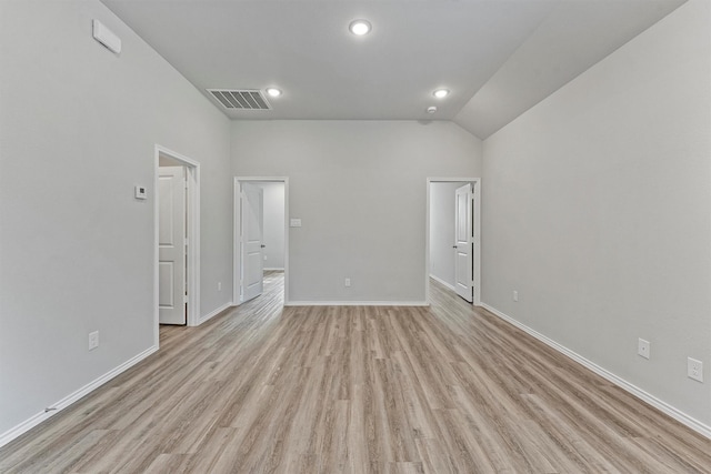 empty room featuring light wood-type flooring and vaulted ceiling