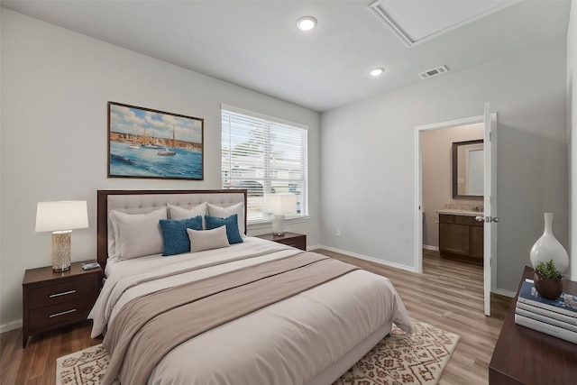 bedroom featuring light hardwood / wood-style floors and ensuite bathroom