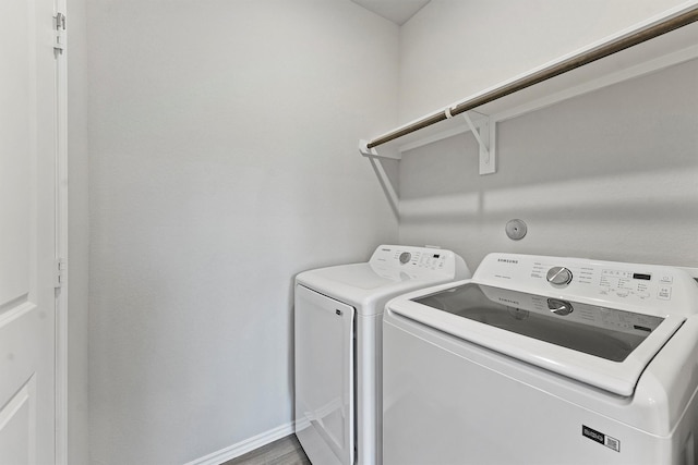 washroom with washing machine and dryer and hardwood / wood-style floors