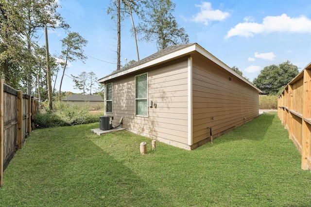 view of outbuilding featuring central AC unit and a lawn