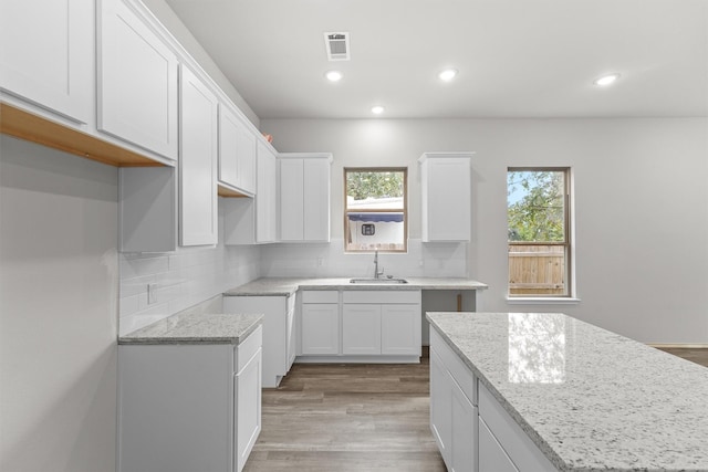 kitchen featuring a wealth of natural light, sink, white cabinetry, and a kitchen island