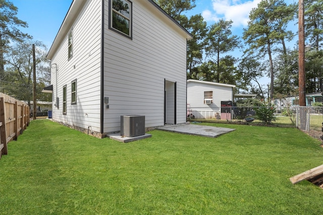 rear view of property with a patio area, central AC, and a yard