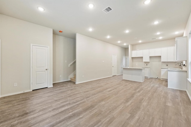 unfurnished living room with sink and light wood-type flooring