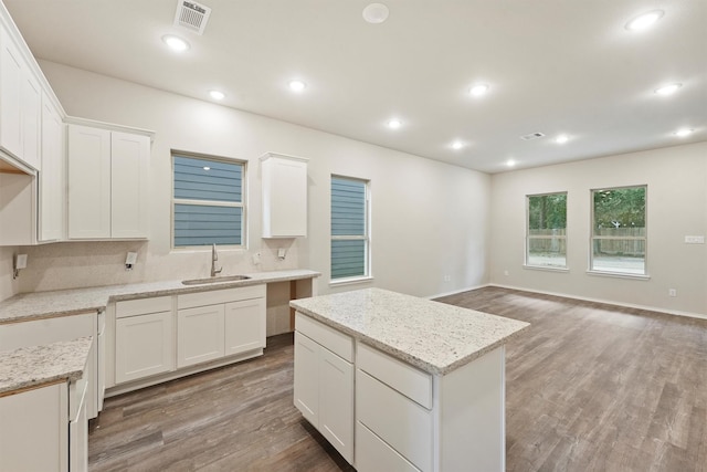 kitchen featuring white cabinets, sink, and a center island