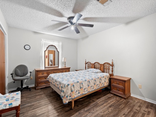 bedroom featuring dark wood-type flooring, a textured ceiling, and ceiling fan