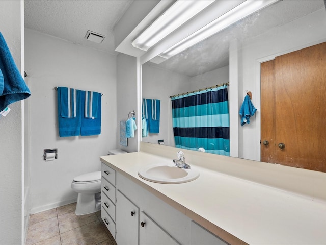 bathroom featuring tile patterned flooring, vanity, a textured ceiling, and toilet