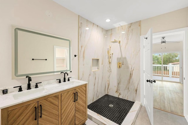 bathroom with tiled shower, vanity, and tile patterned flooring