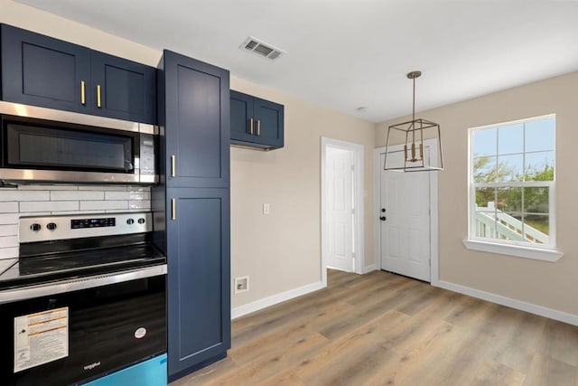 kitchen with appliances with stainless steel finishes, a notable chandelier, light wood-type flooring, blue cabinets, and hanging light fixtures