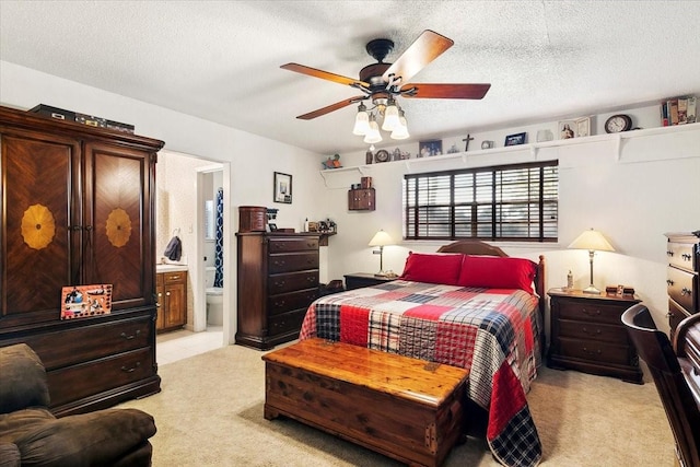 carpeted bedroom featuring ceiling fan, ensuite bath, and a textured ceiling