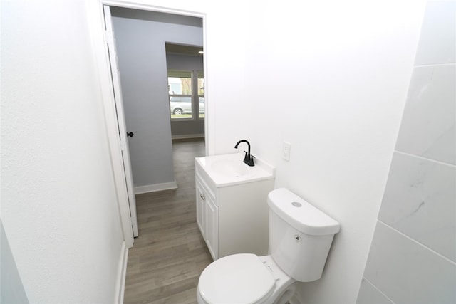 bathroom featuring wood-type flooring, toilet, and vanity