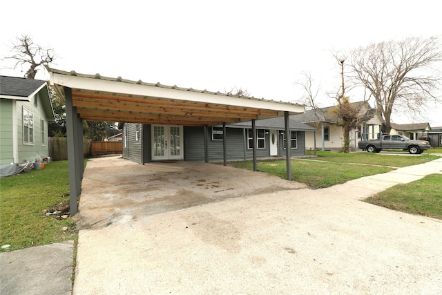 view of front of house with a front yard, french doors, and a carport