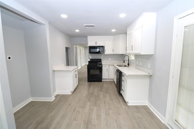 kitchen featuring black appliances, sink, white cabinetry, and light hardwood / wood-style floors