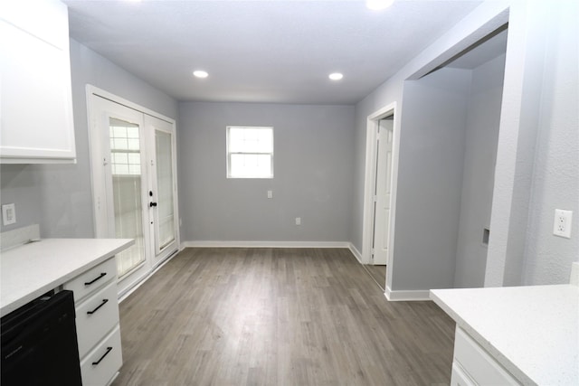 interior space featuring light wood-type flooring, white cabinets, french doors, and dishwasher