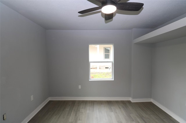 spare room with ceiling fan, dark wood-type flooring, and a textured ceiling