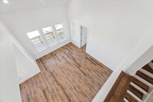 interior space featuring a towering ceiling and light hardwood / wood-style flooring