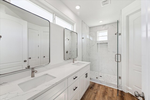 bathroom with vanity, wood-type flooring, and a shower with door