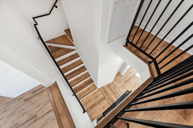 staircase with hardwood / wood-style flooring