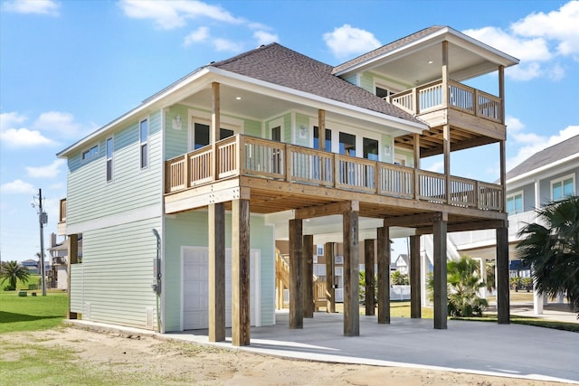 rear view of property featuring a balcony, a garage, and a carport