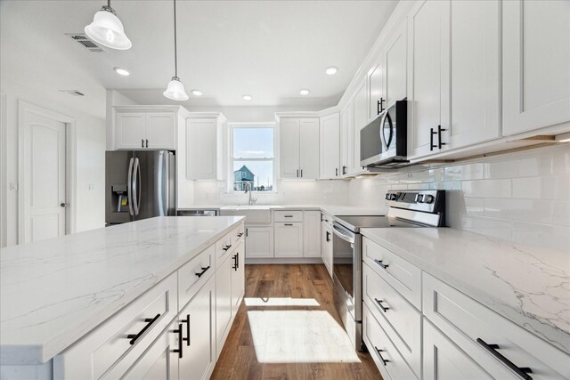 kitchen featuring white cabinetry, backsplash, pendant lighting, and stainless steel appliances