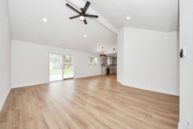 unfurnished living room featuring ceiling fan, sink, light hardwood / wood-style flooring, and vaulted ceiling with beams