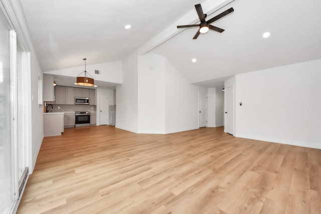 unfurnished living room featuring ceiling fan, light hardwood / wood-style flooring, and lofted ceiling with beams