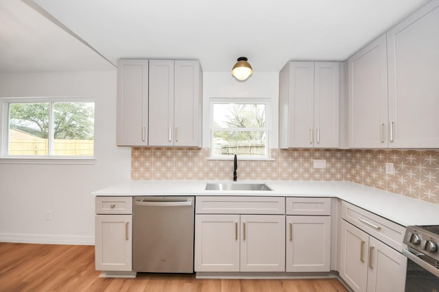 kitchen featuring a wealth of natural light, backsplash, sink, and stainless steel appliances