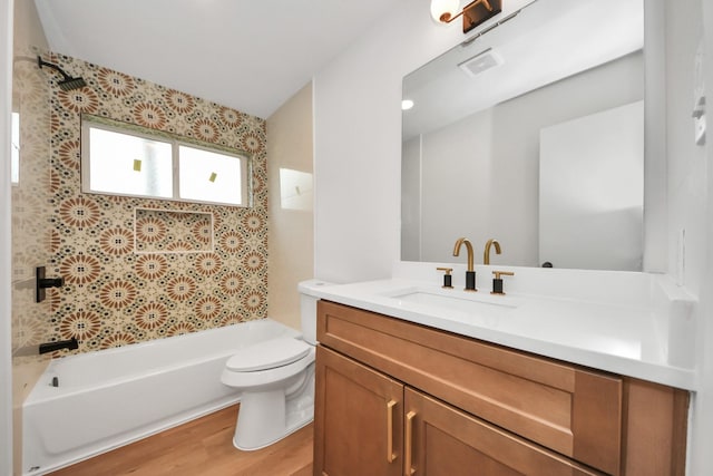 full bathroom with toilet, vanity, wood-type flooring, and tiled shower / bath combo